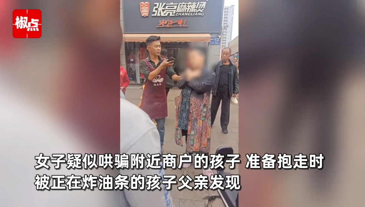 女子当街哄骗抱走小孩，被孩子亲爹当场抓住，路人群情激奋：打她！